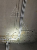 Фото армированного трубопровода системы форсуночного увлажнения с креплением прорезиненными хомутами к бетонному перекрытию