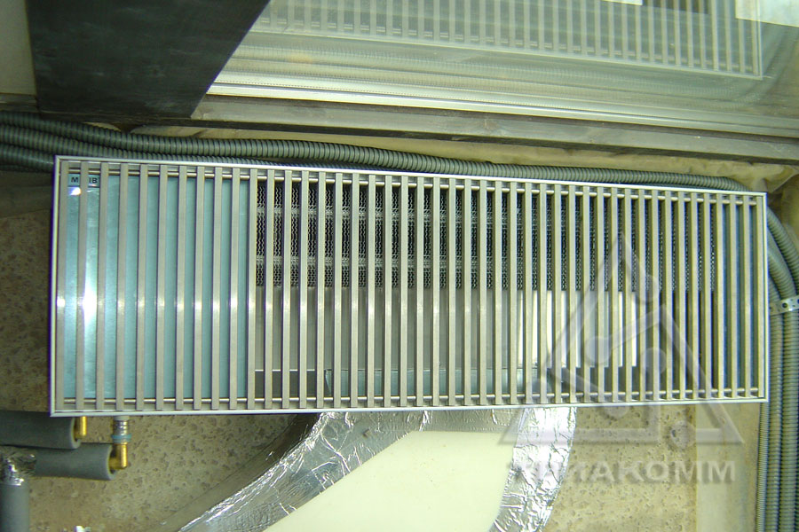 Фото выполненного монтажа отопительных конвекторов под витражными окнами