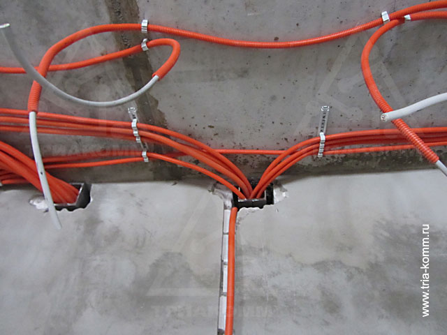 Фото электрических кабелей в защищающих гильзах, проходящих через строительные конструкции