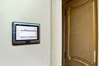 Фото сенсорной панели AMX в гостевой спальне с интерфейсом управления аудиоаппаратурой