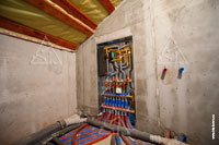 Фото выполненного монтажа отопительного коллекторного шкафа и труб канализации