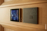 Фото термостата Thermokon LCF Touch и 1-кнопочного выключателя CJC Systems на двери в помещении