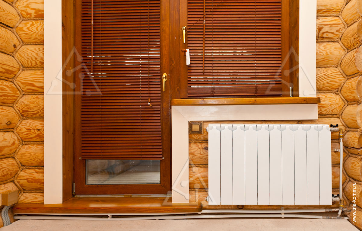 Фото панельного радиатора отопления у окна в комнате загородного дома